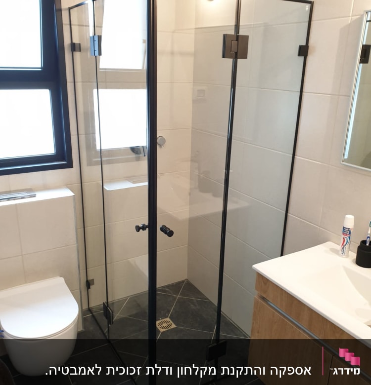מקלחון זכוכית עם דלתות שחורות בחדר אמבטיה